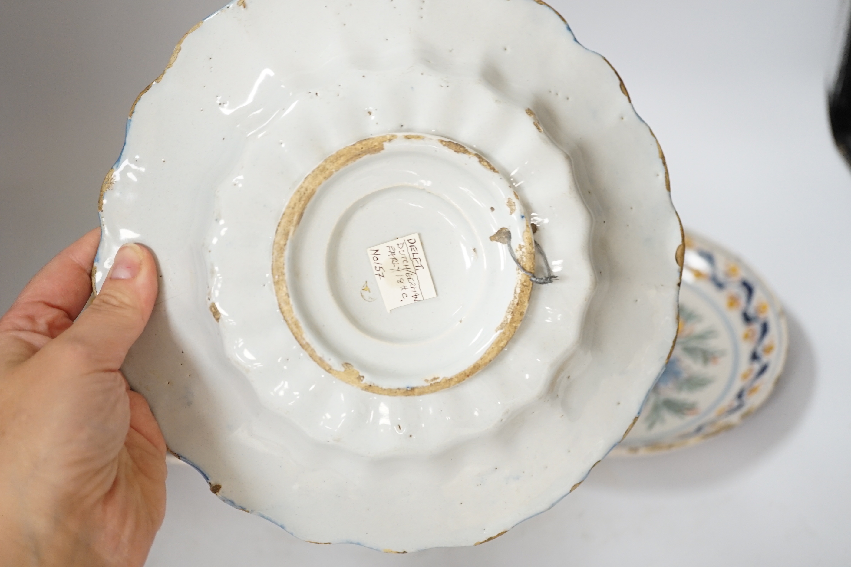 A Delft blue and white dish, c.1700 and two 18th century Delft polychrome dishes, 22cm (3)